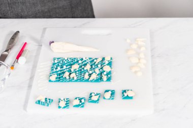 Çiseleyen beyaz çikolata ve üzerine beyaz inci şekeri serpiştiren mini çikolata ozanı.