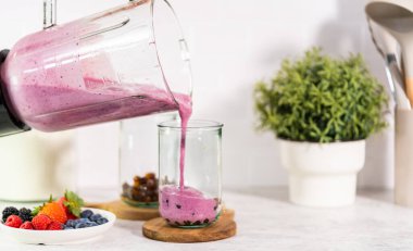 Taze yapılmış meyveli buzlu içeceği bardağa dolduruyorum..