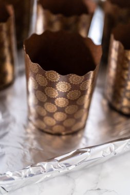 Paskalya ekmeği pişirmek için ekmek hamurunu kağıt kalemin içine karıştırmak..