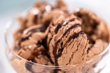 Ev yapımı çikolata parçalı dondurmayı cam bir kasede çikolatayla servis ediyorum..