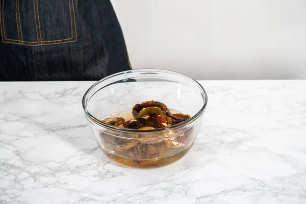 stock image Soaking dehydrated wild mushrooms in a glass mixing bowl with hot water.