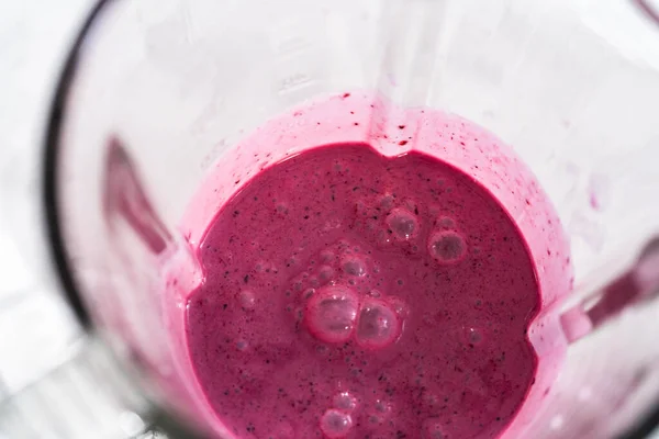 stock image Mixing ingredients in kitchen blender to prepare mixed berry boba smoothie.