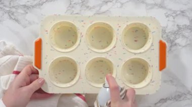 Time lapse. Step by step. Flat lay. Filling silicone muffin pan with ingredients to bake bacon and cheese egg muffin.