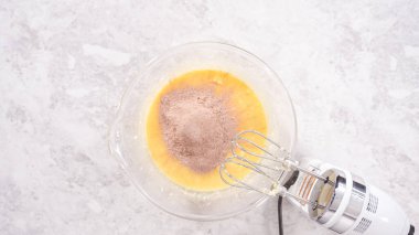 Düz yatıyordu. Adım adım. Kırmızı kadife kek hazırlamak için karıştırma kabındaki malzemeleri karıştırıyorum..