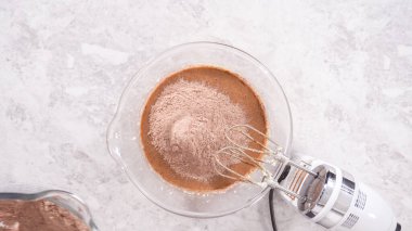 Düz yatıyordu. Adım adım. Kırmızı kadife kek hazırlamak için karıştırma kabındaki malzemeleri karıştırıyorum..