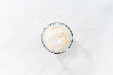 Düz yatıyordu. Beyaz çikolatalı macadamia fındığı pişirmek için bardakta çırpma kabıyla kurutulmuş malzemeleri karıştırıyorum..