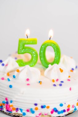 Beyaz bir pasta tabağında 50. yaş günü pastası..