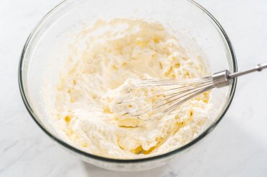 Ev yapımı krem şantiyi hazırlamak için cam bir karıştırma kabında malzemeleri karıştırıyorum..