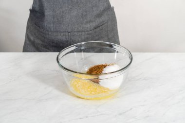 Beyaz çikolatalı macadamia fındığı pişirmek için ıslak malzemeleri büyük bir bardakta karıştırıyorum..
