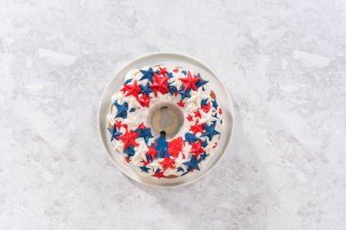 Düz yatıyordu. 4 Temmuz pasta vanilya jöleli ve beyaz bir tabakta çikolata yıldızlarıyla süslenmiş..