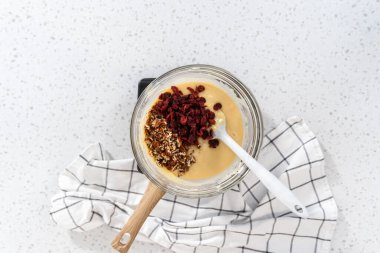 Düz yatıyordu. Beyaz çikolata parçacıkları ve diğer malzemeleri kaynamış suyun üzerine karıştırıp beyaz çikolatalı fındıklı fındıklı çikolata hazırlıyorum..