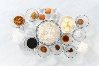 Düz yatıyordu. Bardaktaki ölçülü malzemeler zencefilli kek ve karamel dolgulu kek pişirmek için karıştırılıyor..