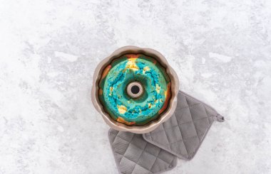 Düz yatıyordu. Mutfak tezgahındaki kek kalıbında taze pişmiş kek..