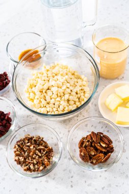 Beyaz çikolatalı fındıklı fındıklı çikolata yapmak için cam karıştırma kabında ölçülmüş malzemeler..