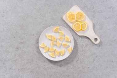 Düz yatıyordu. Beyaz bir tabakta dilimlenmiş organik limon dilimleri..