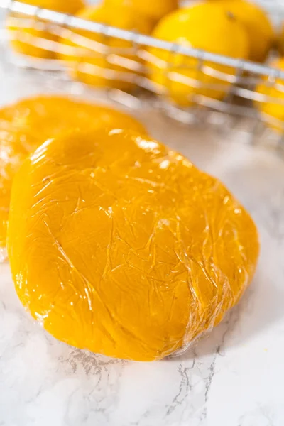 レモンくさびクッキーとレモン釉薬 冷蔵庫で冷やすためのクッキー生地をラップレモンウェッジクッキーをレモン釉薬で焼く — ストック写真