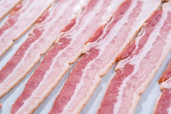 Tiras Bacon Não Cozidas Uma Assadeira Com Papel Manteiga Branco — Fotografia de Stock