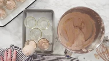 Time lapse. Flat lay. Step by step. Scooping homemade chocolate ice cream into glass jars.
