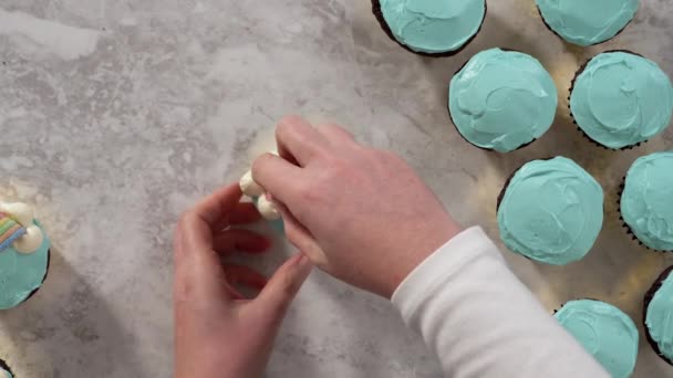 平躺在床上用奶油 糖霜和彩虹糖装饰巧克力杯蛋糕 — 图库视频影像