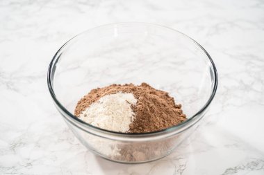 Büyük bir bardaktaki malzemeleri karıştırarak naneli çikolatalı kekler pişiriyorum..