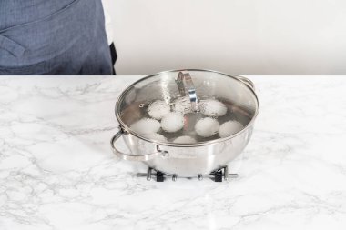 Haşlanmış yumurta pişirmek için tencerede beyaz yumurta kaynatmak..