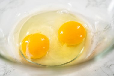 Büyük bir bardaktaki malzemeleri karıştırarak naneli çikolatalı kekler pişiriyorum..