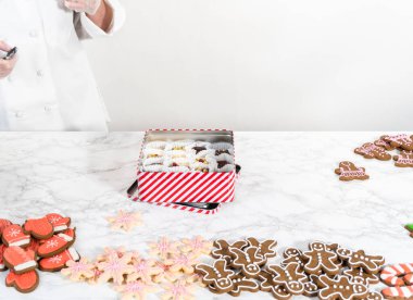 Noel yemeği için ev yapımı şekerleme ve zencefilli kurabiye paketlerini teneke kutulara koyuyoruz..