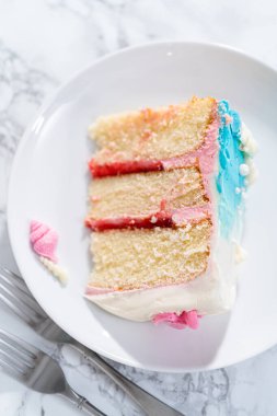 Deniz kızı temalı 3 katlı vanilyalı pasta dilimi. Çikolatalı deniz kızı kuyruğu ve beyaz tabakta deniz kabukları..