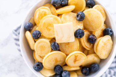 Taze yapılmış mini krep gevreği ve beyaz kasede taze yaban mersini..