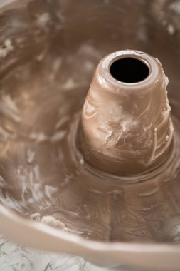 Kek pişirmek için metal tepsiyi yağlamak.