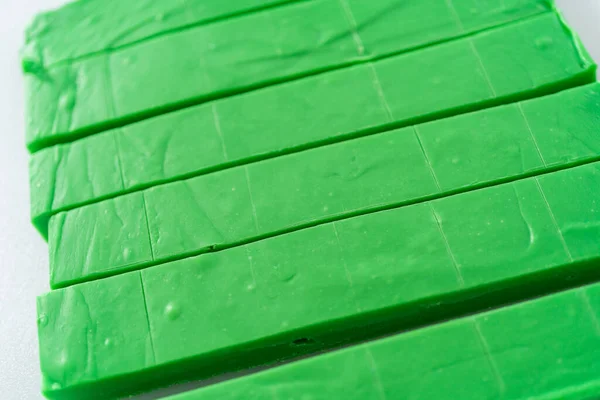 Разрезание Зеленой Помадки Большим Кухонным Ножом Квадратные Куски Белой Доске — стоковое фото