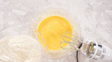 Düz yatıyordu. Adım adım. Fünyeli kek pişirmek için karıştırma kabındaki malzemeleri karıştırıyorum..