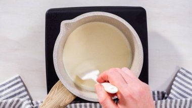 Adım adım. Düz yatıyordu. Elektrikli bir tavanın üzerinde küçük bir tencereyle çikolata kreması hazırlıyorum..