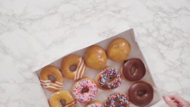 Düz yatıyordu. Beyaz bir karton kutuda mağazadan alınmış donutların çeşitliliği.
