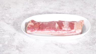 Adım adım. Pişmemiş pastırma şeritleri büyük beyaz bir tabakta..