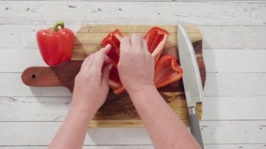 Düz yatıyordu. Ağaç kesme tahtasında organik kırmızı dolma biber kesiyorum..