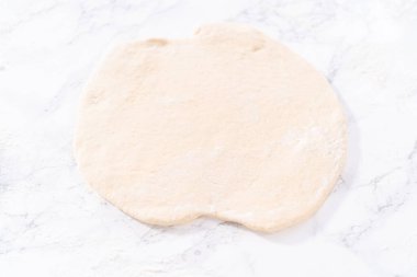 Tarçınlı tatlı pizzası hazırlamak için Fransız merdanesiyle pizza hamuru yuvarlıyorum..