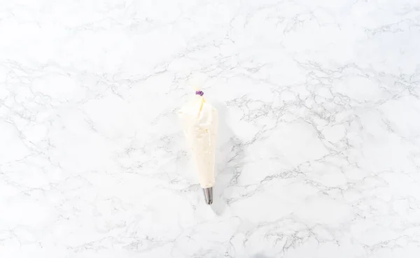 平置きだ アメリカンフラッグミニカップケーキを飾るためにパイピングバッグにバタークリームの霜降りを転送 — ストック写真