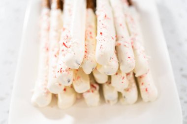 Beyaz servis tabağında ev yapımı çikolata kaplı çubuk kraker yığını..