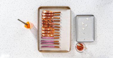 Düz yatıyordu. Çubuk krakerleri erimiş çikolataya batırıp Cadılar Bayramı 'nda çikolata kaplı çubuk kraker yapmak..