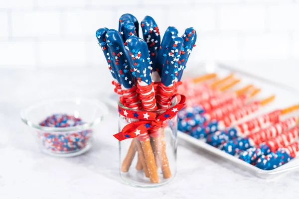 自制巧克力覆盖的椒盐卷饼棒 装饰得像玻璃瓶中的美国国旗 — 图库照片