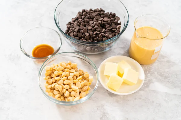 Çikolatalı macadamia şekerlemesi yapmak için cam karıştırma kabında ölçülmüş malzemeler..