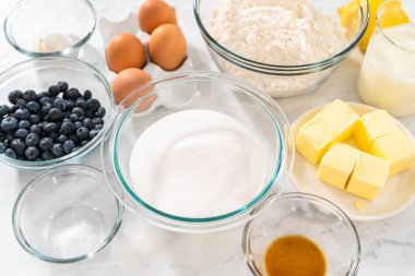 Limonlu yaban mersinli kek pişirmek için bardakların içindeki ölçülü malzemeler..