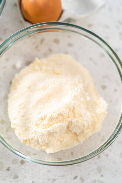 Измеренные ингредиенты в стеклянных мисках для выпечки простого ванильного торта из коробочного торта.