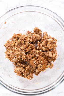 Tarçın kırıntılarını hazırlamak için büyük bir bardakta karışımı karıştırıyorum..