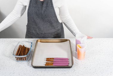 Çubuk krakerleri erimiş çikolataya batırıp Cadılar Bayramı 'nda çikolata kaplı çubuk kraker yapmak..