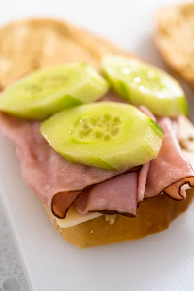 Assembling Ham Cucumber Sprout Sandwiches White Cutting Board — Stok fotoğraf