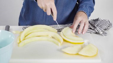 Adım adım. Beyaz kesme tahtasında kaygan altın çiğ taneli kavun.