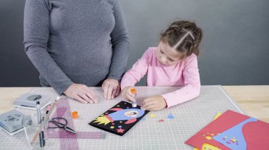 El yapımı Babalar Günü kartı hazırlayan küçük bir kız..