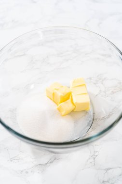 Mini vanilyalı kekler ve ombre pembe kremalı krema pişirmek için büyük bir karıştırma kabında malzemeler karıştırılıyor..